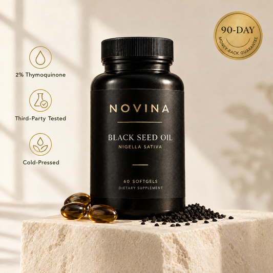 NOVINA Black Seed Oil bottle with amber softgels and black seeds on a cream stone pedestal